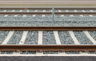 Pattern of railway tracks on gravel as a side view. Rails lead to Helsinki. Steel construction of...