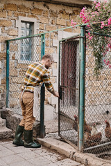 Modern farmer tending to chickens in a charming rural setting at sunset