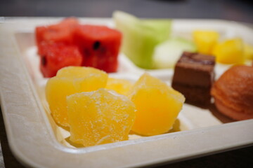 ビュッフェ用の器に盛り付けられた鮮やかなみかんの果肉入りわらび餅。ぷるぷるとした透明感ある食感とフルーツの爽やかな甘さが、夏の涼菓として涼しげな雰囲気を演出するデザート写真。