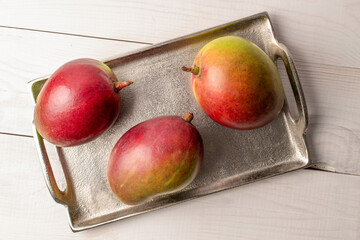 Sweet juicy mangoes on a wooden table, top view, macro.	