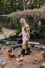 Modern farmer tending to chickens in a picturesque rural landscape at golden hour