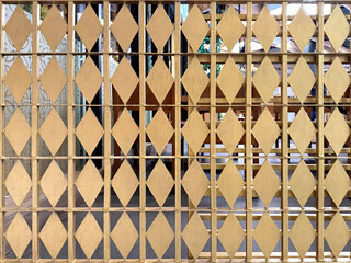 Close up of screens divider decoration made of metal plate in diamond shape and in gold colors. Suitable for interior wall panel decoration. Seamless background texture.