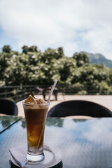 Refreshing iced coffee topped with whipped cream and cinnamon on a table of a panoramic terrace...