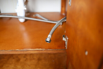 Close up image of a isolated of a water supply hose  under bathroom sink