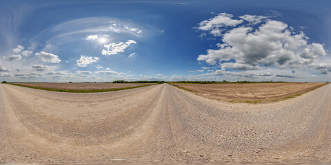 Fototapeta premium hdri 360 panorama view on crossroads of gravel country roads among fields with clouds in sky in equirectangular full seamless spherical projection, ready for VR AR or sky dome replacement