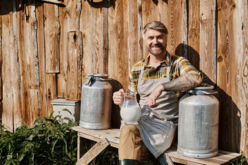 Modern farmer enjoying a joyful moment with fresh milk in the countryside
