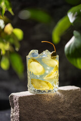 Pickle juice or brine in a glass and jar of pickled cucumbers on a gray background.