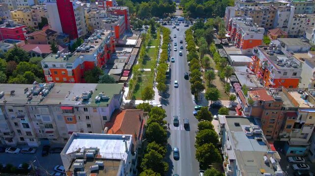 Flat aerial view of a T-junction in Durr&euml;s, Albania, showing intersecting roads, surrounding houses, and urban layout under a sunny sky.