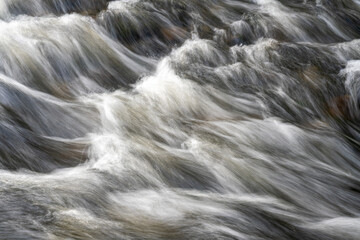Close-up of fast flowing river water with motion blur