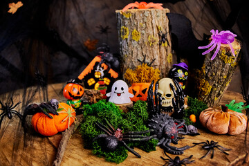 Halloween fun party in a dark forest in a glade with a skull, ghost, spiders, black hands, pumpkins...