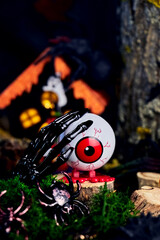 Halloween picture with an eye on a stump, black hand and bugs on All Saints Day in a gloomy atmosphere, creative focus