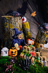 halloween, dark forest, clearing, witch sits on a tree stump in her cozy shelter with spiders, a...