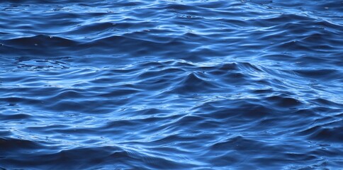 Soft rolling waves on blue water surface