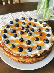 Homemade cheesecake topped with fresh blueberries and sweet caramel drizzle, perfect for dessert