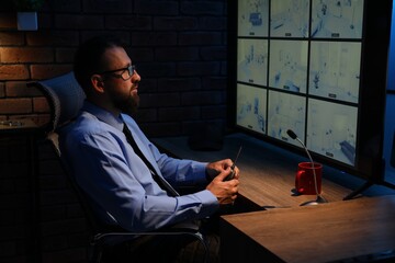 Security guard monitoring CCTV cameras in office at night