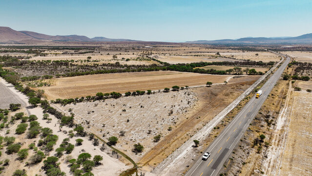 Vista a&eacute;rea de carretera en zona agr&iacute;cola semi&aacute;rida
Paisaje rural con parcelas y camino principal