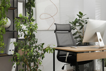 Biophilic interior design. Stylish workplace with computer and houseplants in office