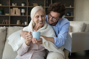 Care and attention. Affectionate caring young man kind grownup child grandson caregiver gently...