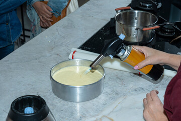 Chef using a kitchen torch to eliminate bubbles from the cheesecake.