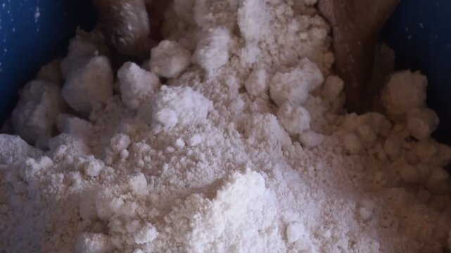 Revirando massa de tapioca em casa de farinha, m&atilde;os feminina preparando a tapioca tradicional do nordeste, goma de mandioca com coco ralado, misturando f&eacute;cula 