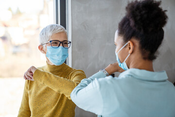 Female professionals in masks using laptop for technology, AI, digital innovation and safe workplace