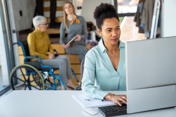 Diverse group of businesspeople discussing charts during a meeting together in a modern office