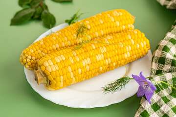 Appetizing corn on a plate with basil and dill