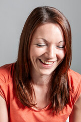 Emotions and Expressions: Candid. A young woman with her eyes closed and a wide smile laughing and...