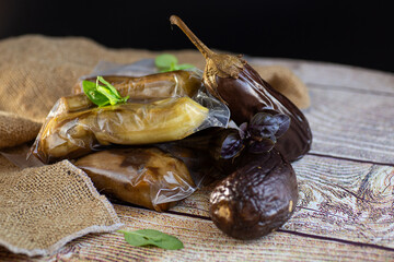 ready-to-freeze eggplants in a vacuum bag lie on a paper baking sheet