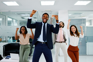 Multi-ethnic business team celebrating success expressing joy and excitement in a modern office environment