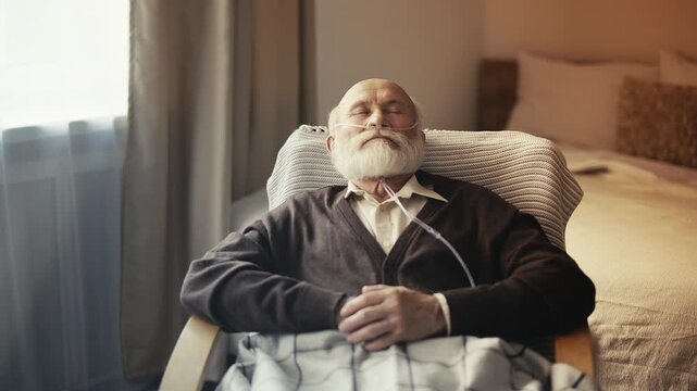 Aged male with nasal cannula napping in armchair, respiratory illness in old age