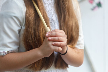 Woman with long brown hair holding a wooden stick
