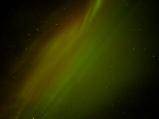 Vibrant green and yellow Northern Lights illuminate a starry night sky over Þjótandi, Iceland,...