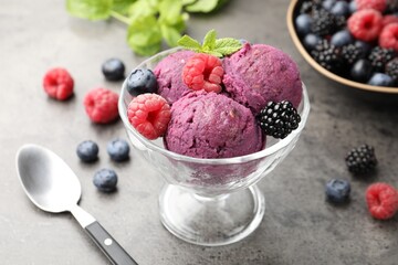 Delicious sorbet with fresh berries and mint in dessert bowl on grey textured table, closeup