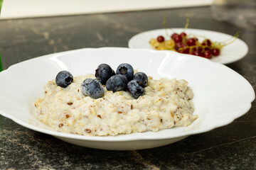 A bowl of oatmeal topped with fresh blueberries.