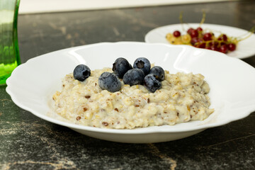 A bowl of oatmeal topped with fresh blueberries. 