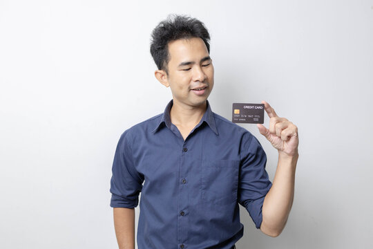 A man stands holding a cell phone, laptop, and credit cards. He is smiling happily and making various gestures for the camera.

 - Powered by Adobe