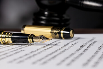 Elegant fountain pen placed on a sheet of paper, symbolizing law, notary, and attorney work. A...