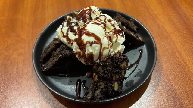 Ice cream with brownie served in a black plate