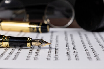 Elegant fountain pen placed on a sheet of paper, symbolizing law, notary, and attorney work. A...