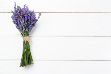 Bunch of beautiful lavender flowers on white wooden table, top view. Space for text
