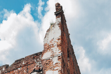 Crumbling Brick Wall of Abandoned Building Against Cloudy Sky