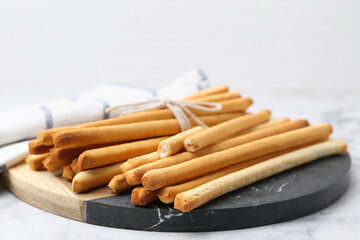 Delicious grissini sticks on light table, closeup