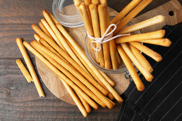 Delicious grissini sticks on wooden table, flat lay