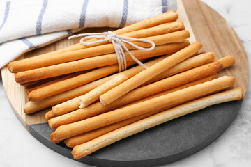 Delicious grissini sticks on light table, closeup