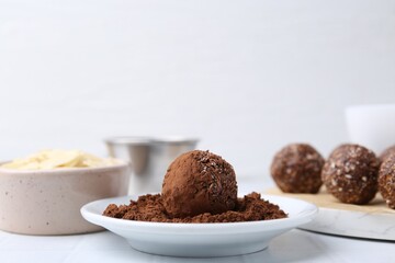 Making homemade candies. Chocolate balls and ingredients on white table, closeup