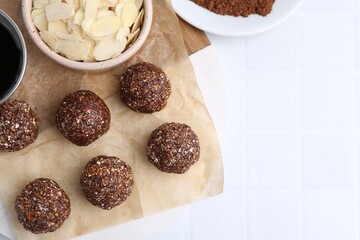 Making homemade candies. Chocolate balls and ingredients on white tiled table, flat lay. Space for...