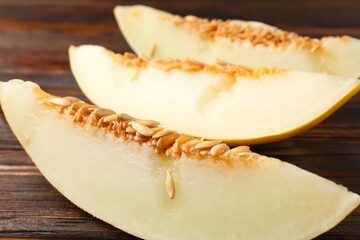 Cut ripe melon on wooden table, closeup