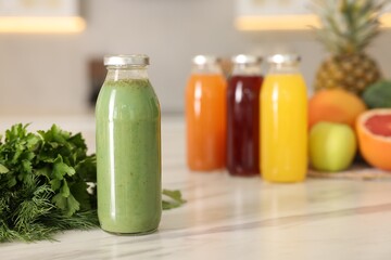 Tasty green juice in glass bottle, parsley and sill on white marble table indoors, closeup. Space for text