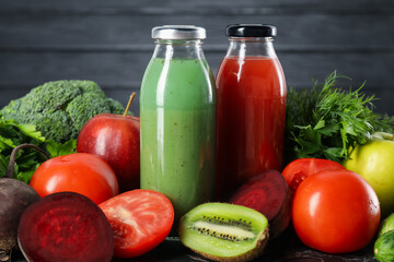 Tasty juices in glass bottles and ingredients on table, closeup